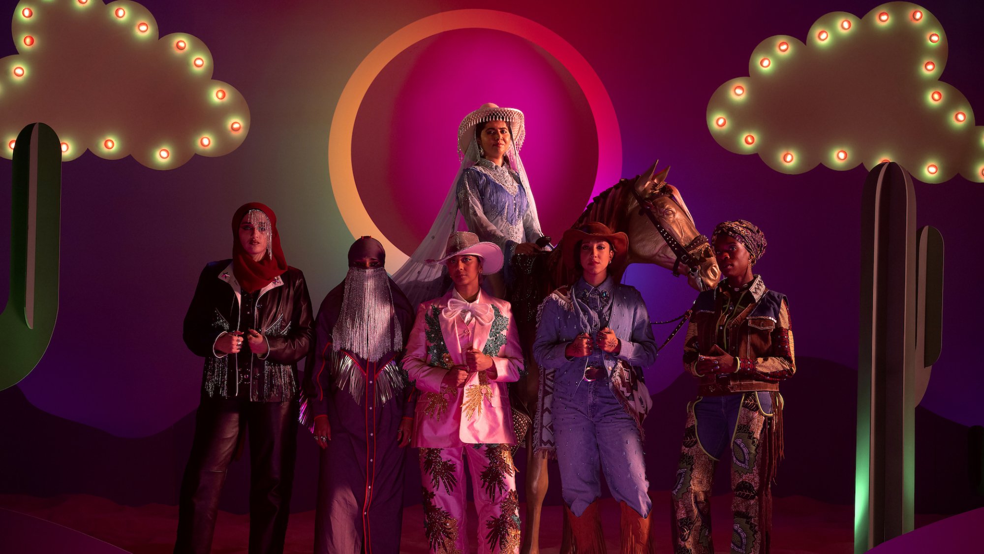 Malala Yousafzai sits on a fake horse in front of the band Lady Parts in the show "We Are Lady Parts"