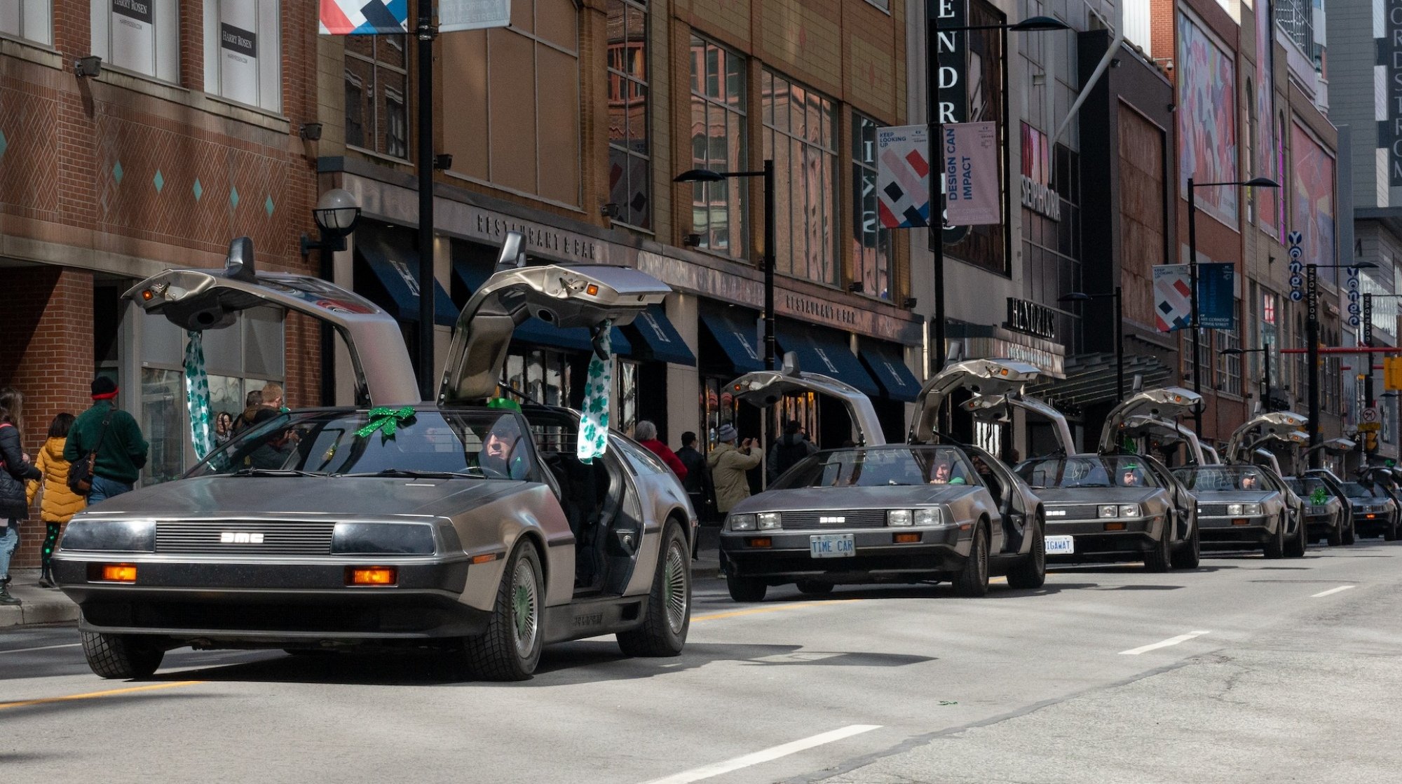 A line of DeLorean cars with their wing doors open