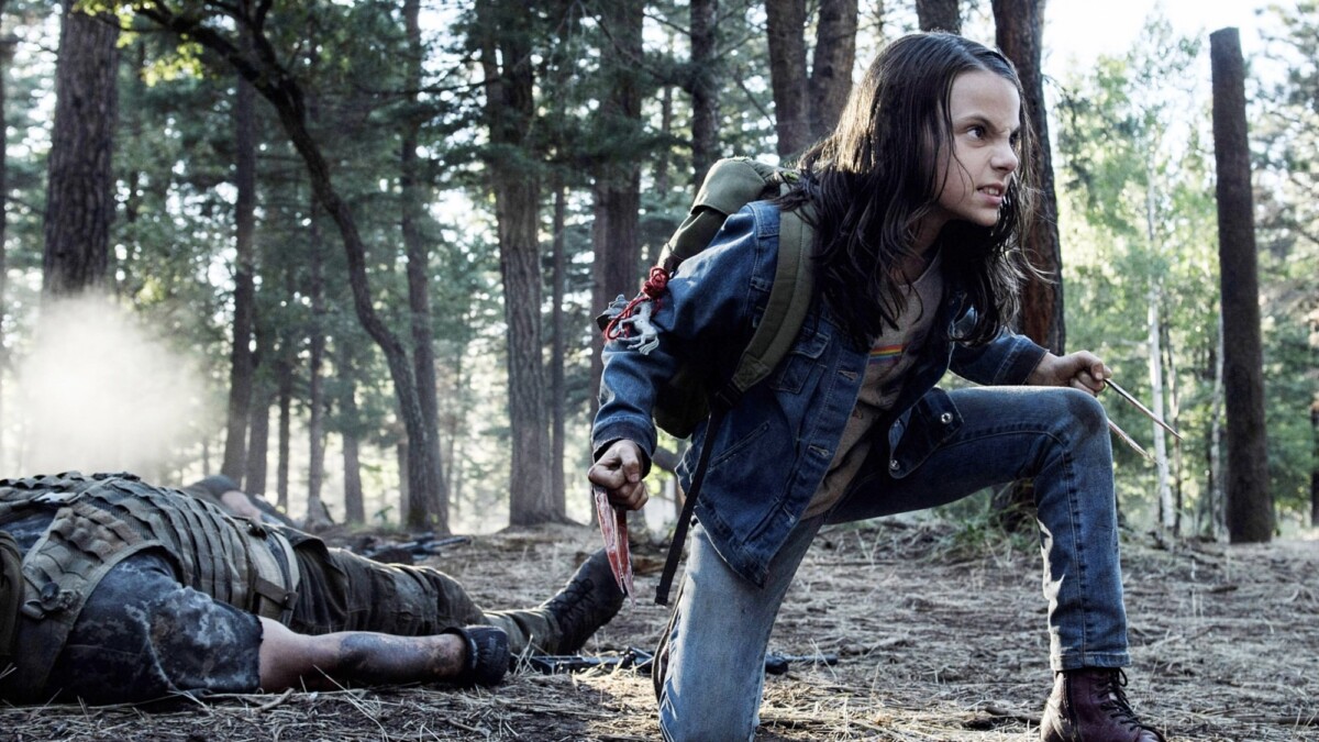 Laura kneels in a fighting stance on the forest ground besides a dead body, claws out.