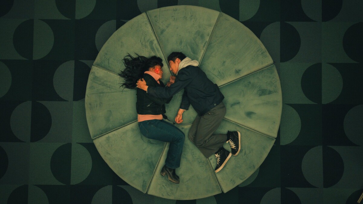 Jennifer (Victoria Sawal) and Ben (Justin H. Min) lie together on a circular lounge in a scene from "The Umbrella Academy."