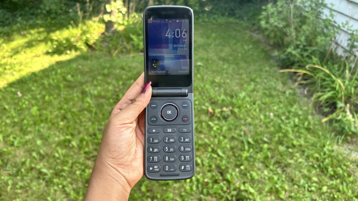 Woman holding TCL Flip 3 in a backyard