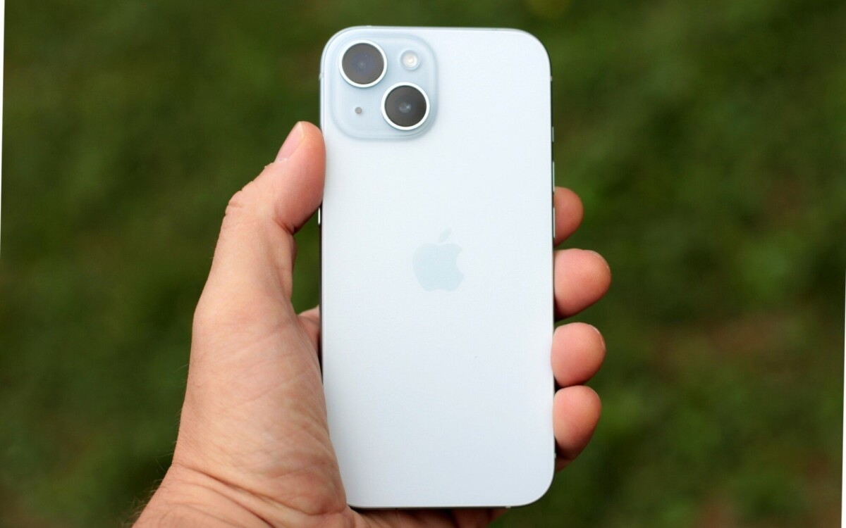 A man holding a light blue iPhone