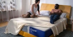 two people on a casper bed smiling at each other