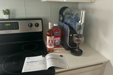 Ingredients for frosé and Ninja recipe book beside Ninja Slushi machine on countertop