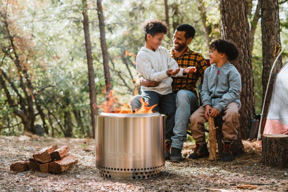 a family sits next to the solo stove bonfire 2.0