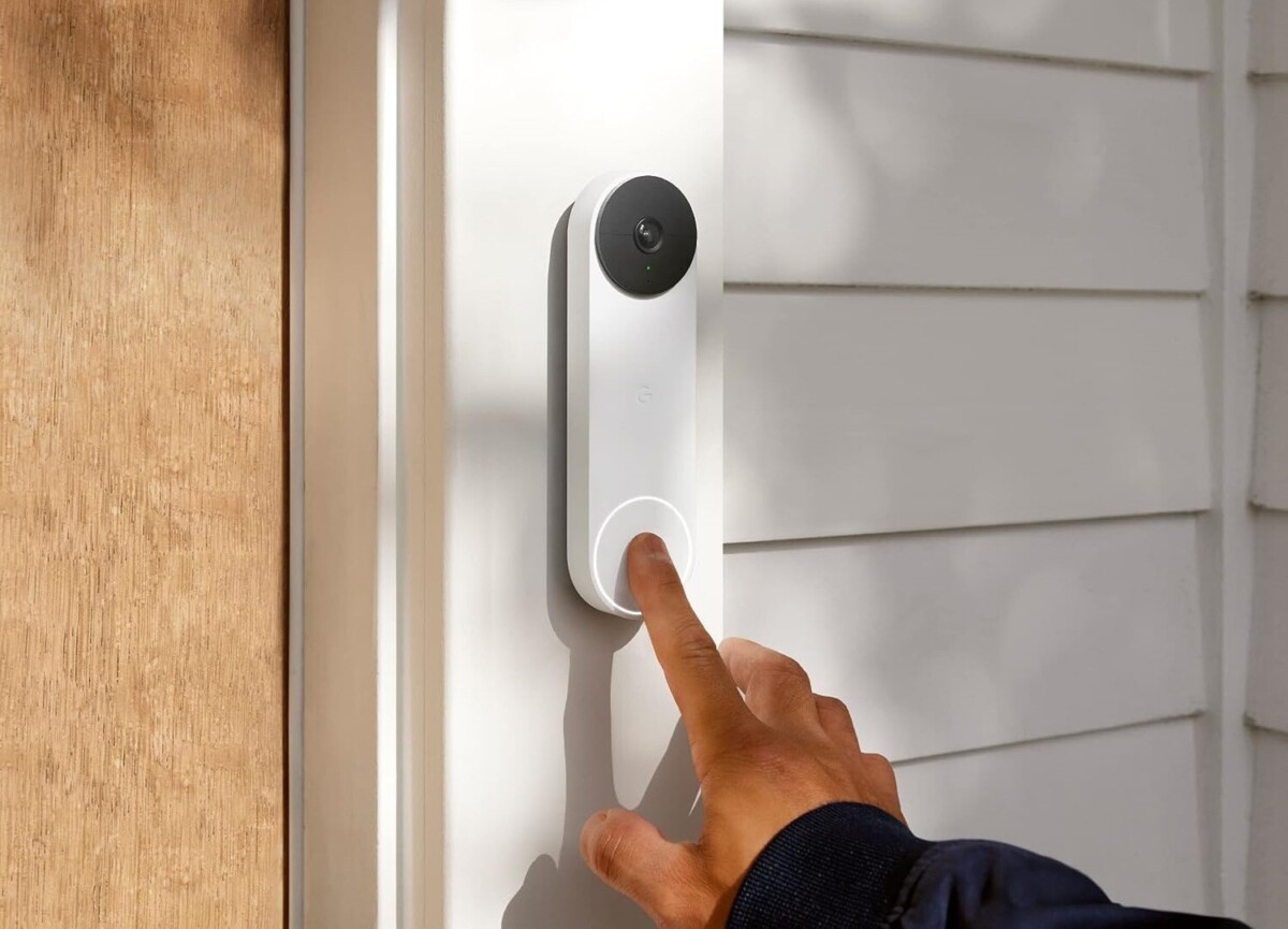 someone uses their index finger to press the bell button on the google next video doorbell that's located to the right side of a front door