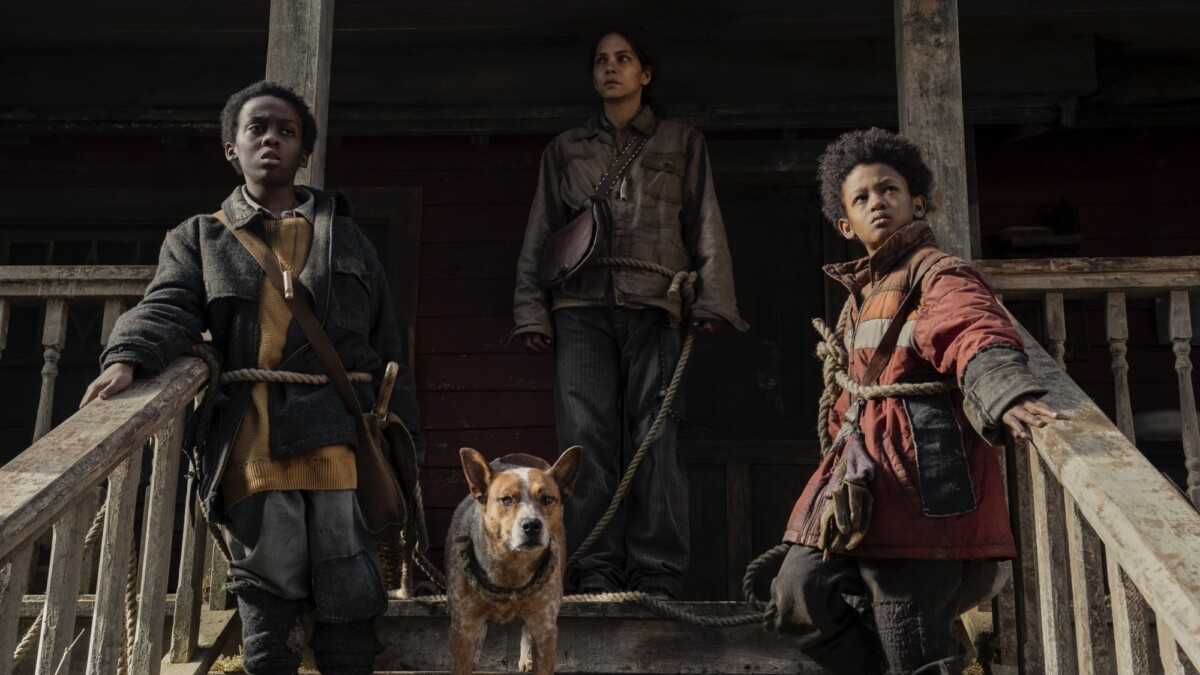 Momma, her sons, and their dog stand on the steps of their house.