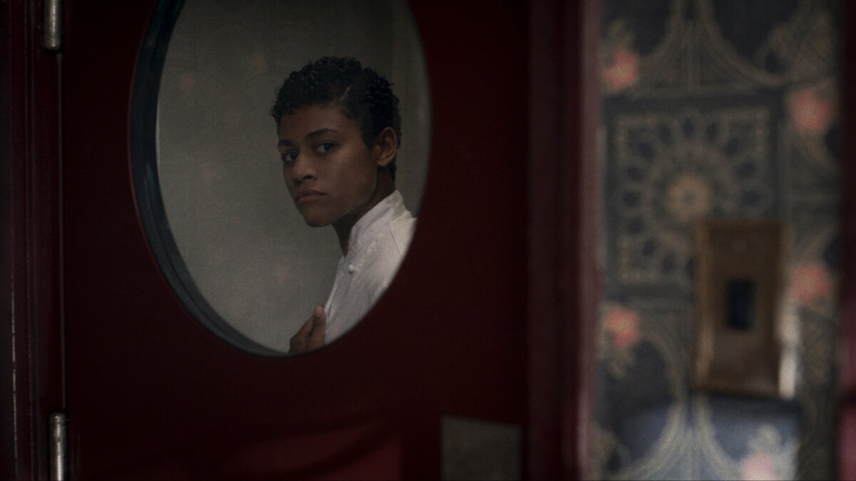 Chef peers through a door in her restaurant.