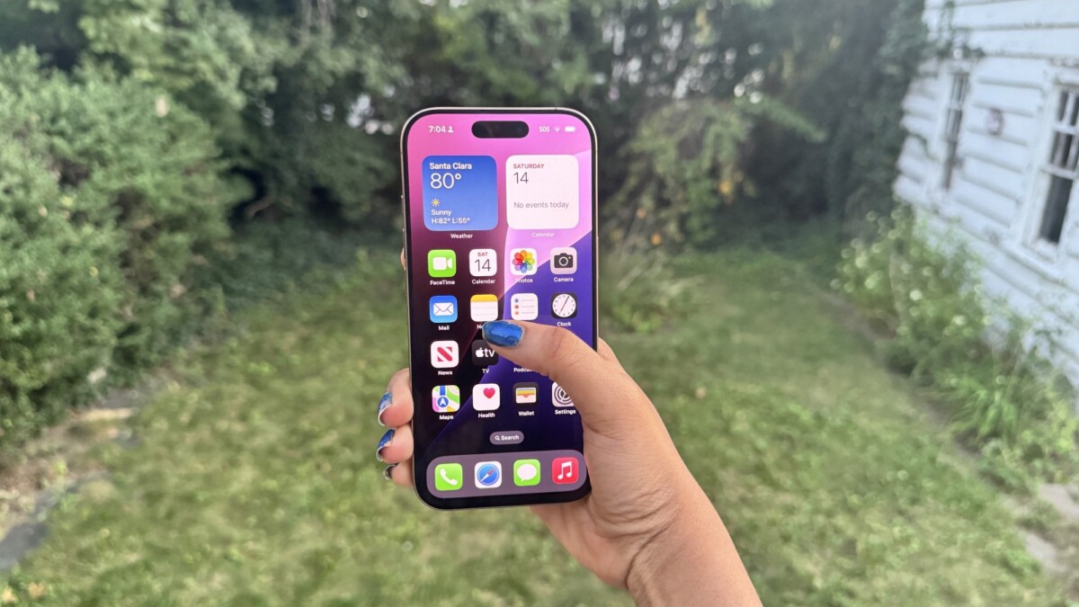 iPhone 16 Pro model in a backyard setting