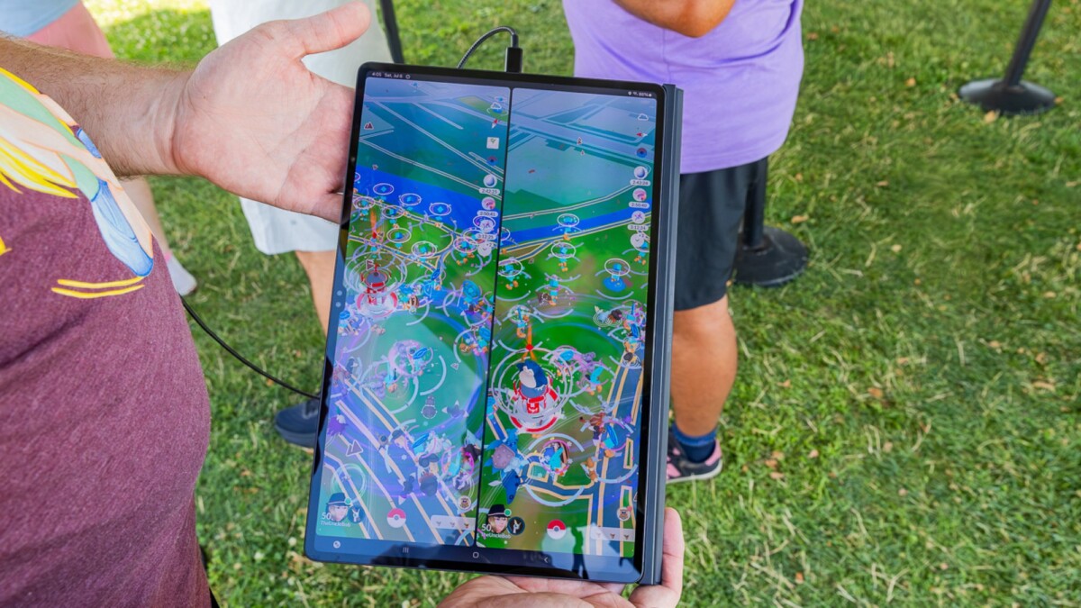 White hands hold a Galaxy Tab S9 Ultra displaying Pokémon GO.