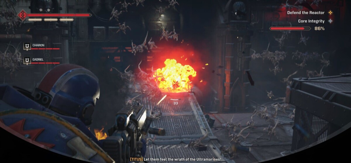 In this image, a Space Marine is seen defending a reactor from a swarm of alien enemies in a dark, industrial environment