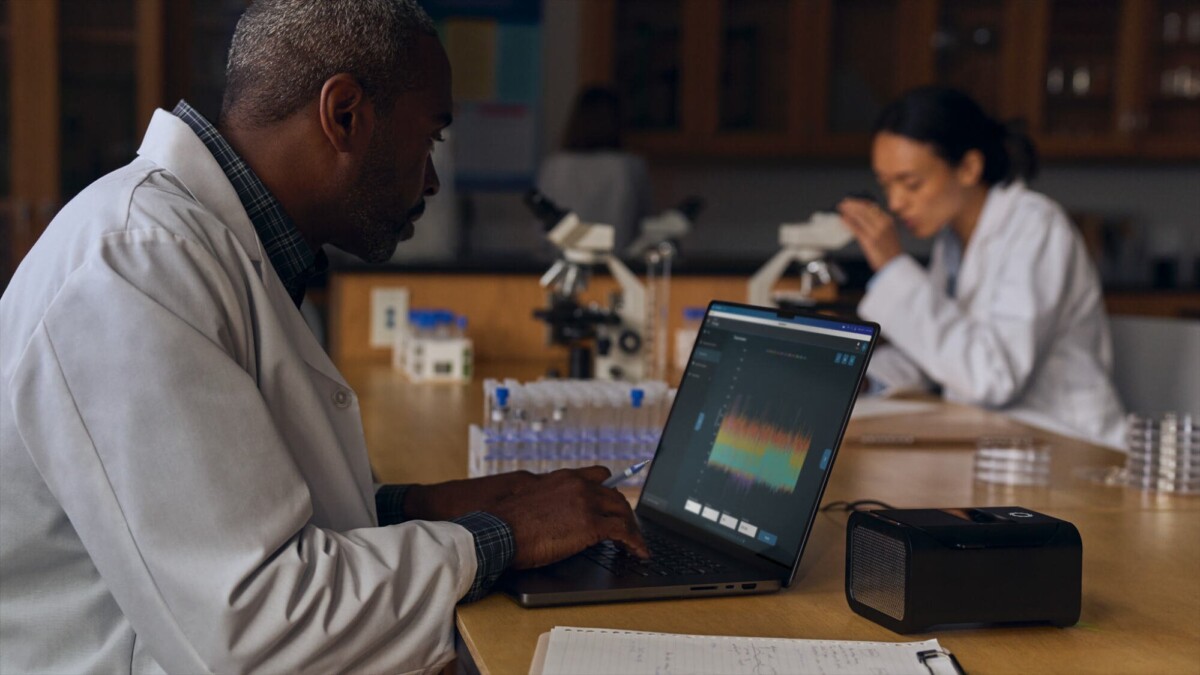 A professional in a lab coat using M4 MacBook Pro