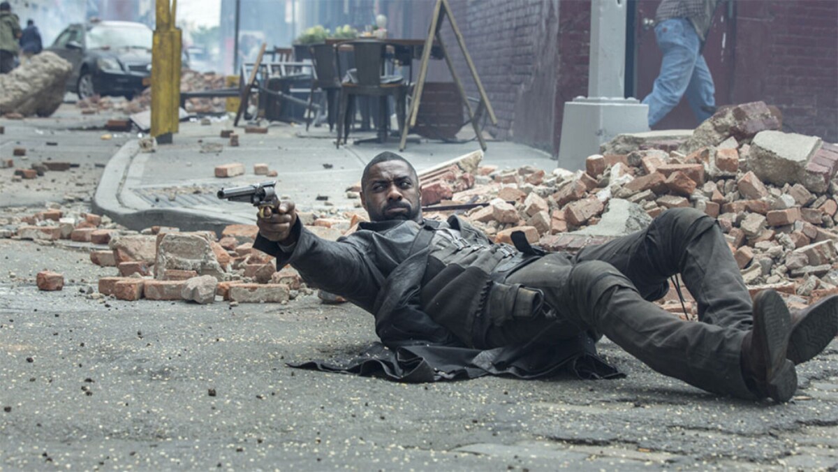 A man fires a gun from a lying-down position.