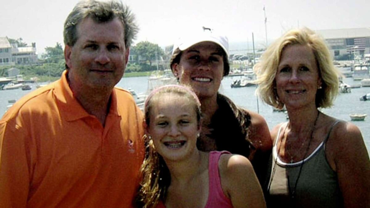 A family smiles for a photo. 