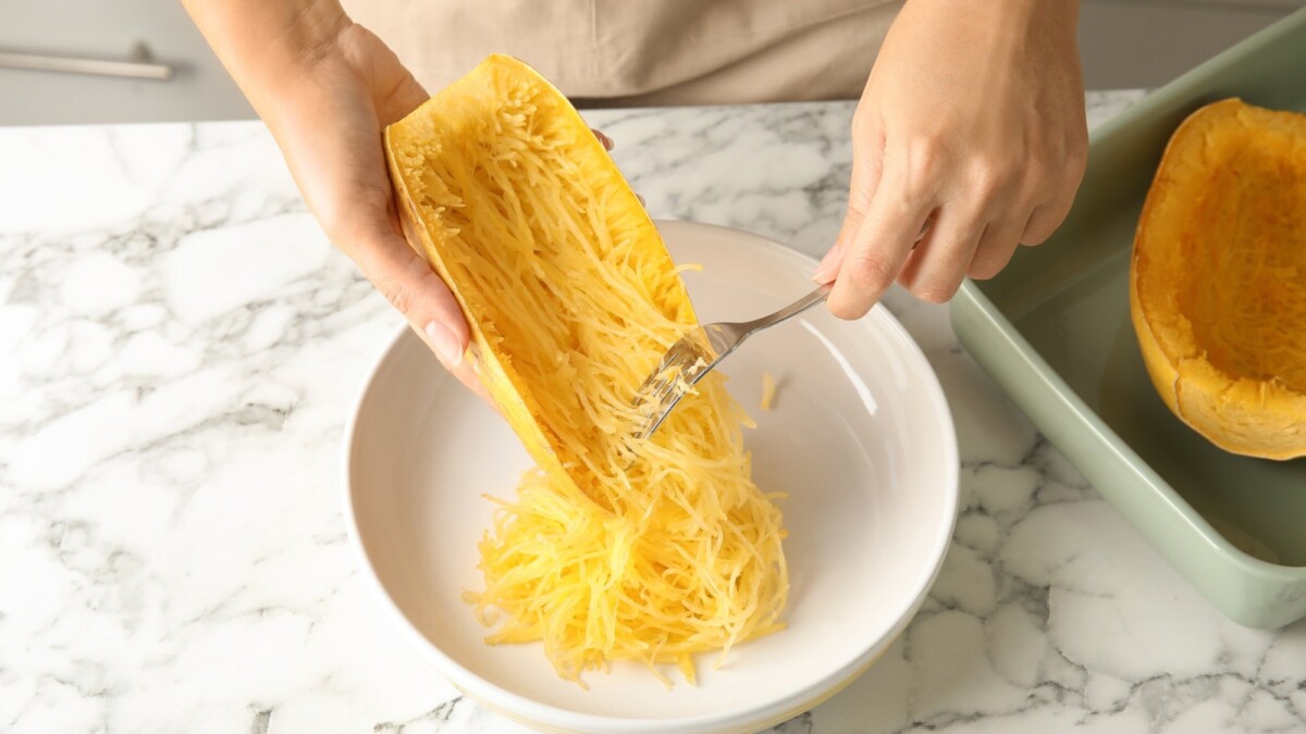 Someone scrapping flesh out of spaghetti squash