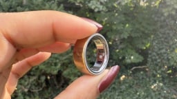 Oura Ring 4 between someone's fingers with leafy background