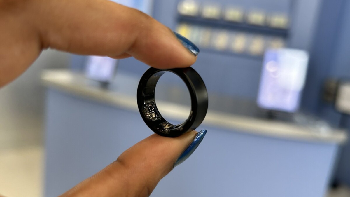 Samsung Galaxy Ring in black in between a pointer finger and thumb