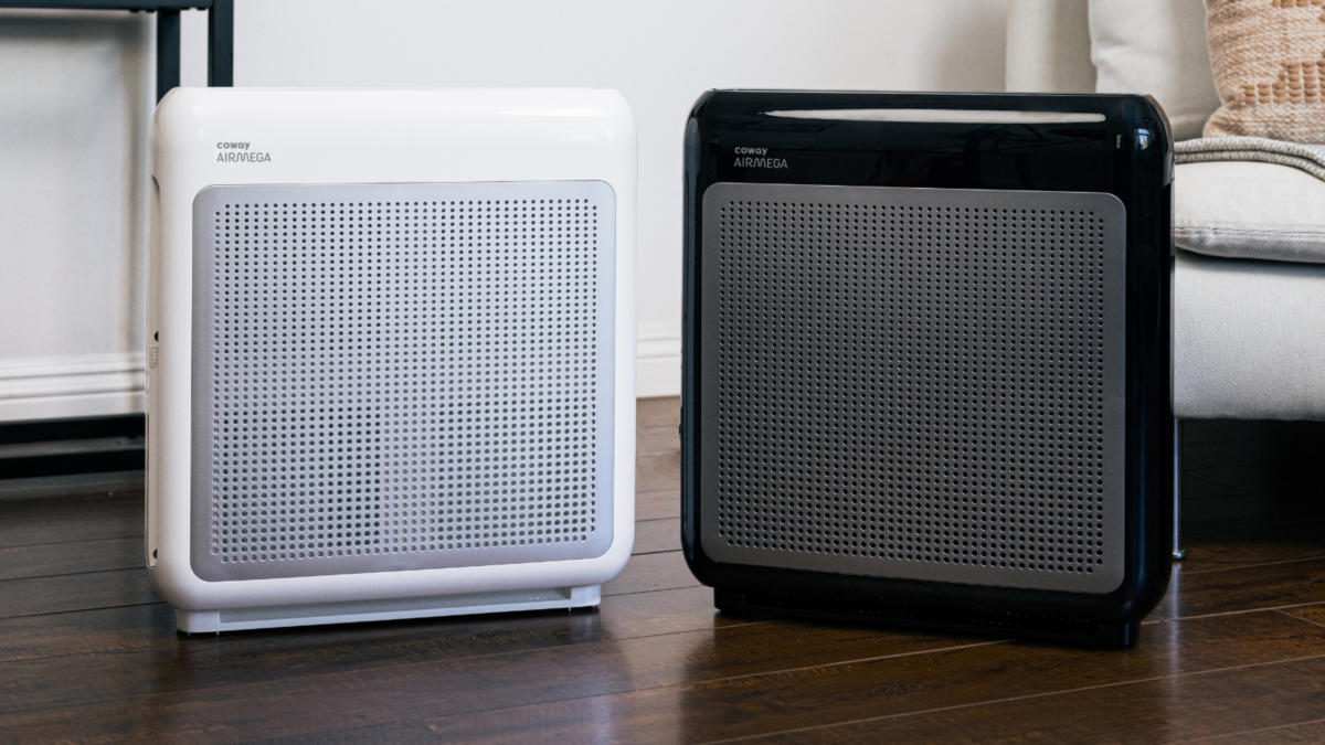 Two Coway Airmega 200M air purifiers side by side, one white and one black.