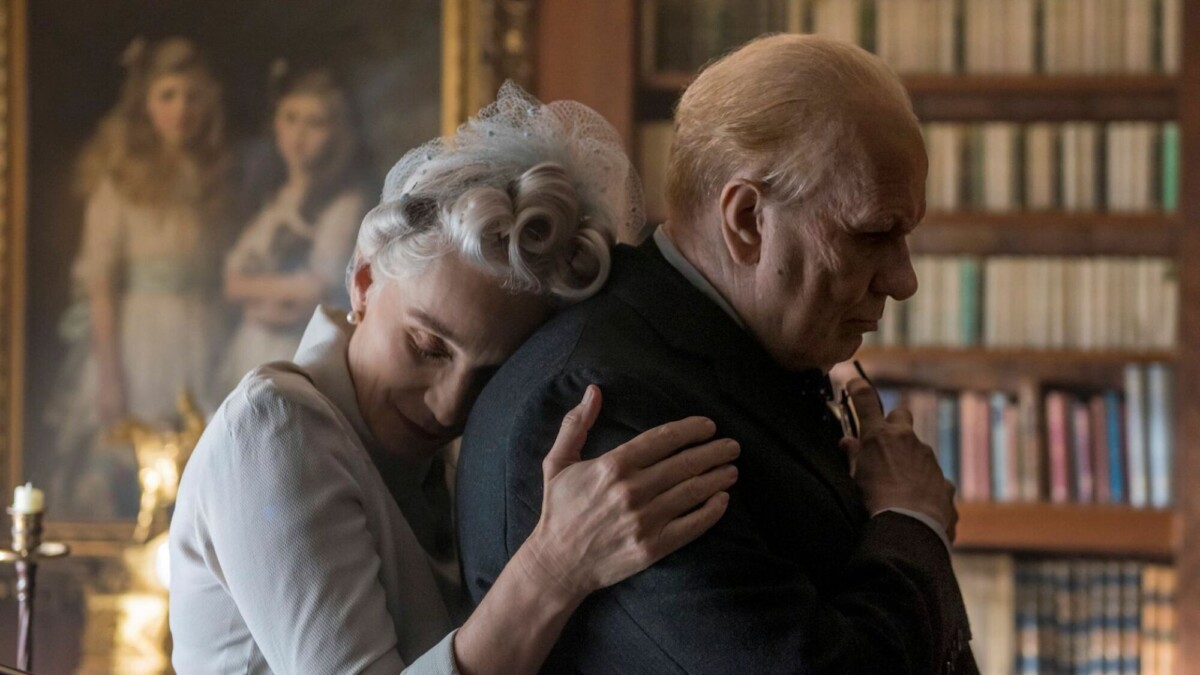 An older woman hugs her husband. 