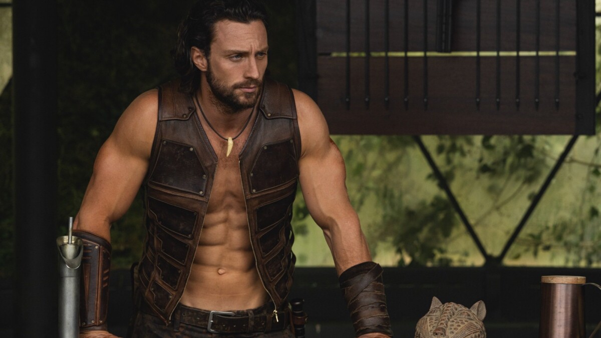 Aaron Taylor-Johnson flexes his arms in "Kraven the Hunter."