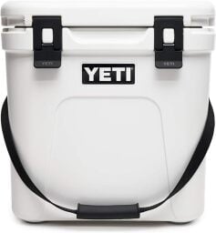 White cooler with black straps. Says YETI in the middle