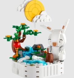 The Lego Jade rabbit set appears on gray, with a sun, rabbit, stream and small tree.