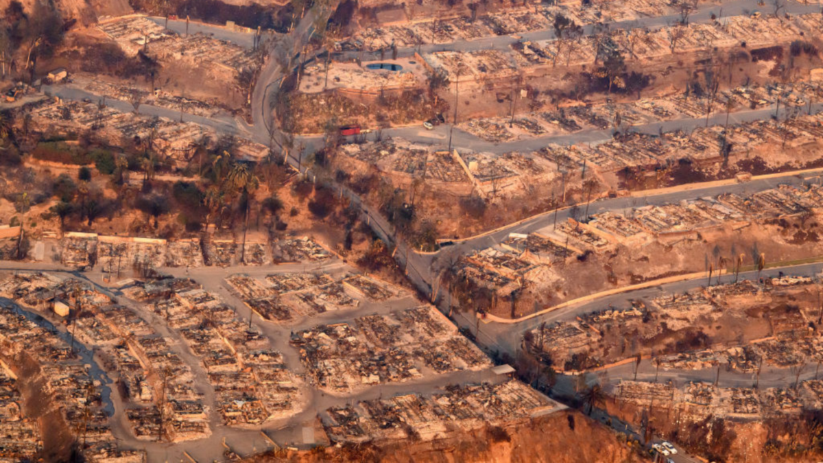 In this aerial view taken from a helicopter, homes burned from the Palisade fire smolder near the Pacific Palisades neighborhood of Los Angeles, California on January 9, 2025.